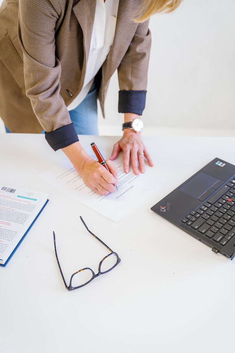 Melissa greenwell, working on a desk, writing coaching notes