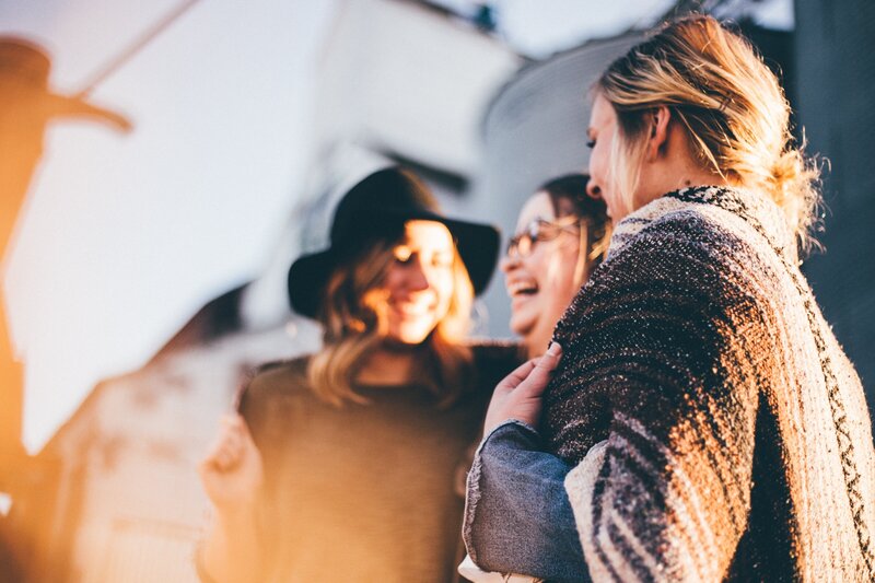 Three women talking and laughing happily