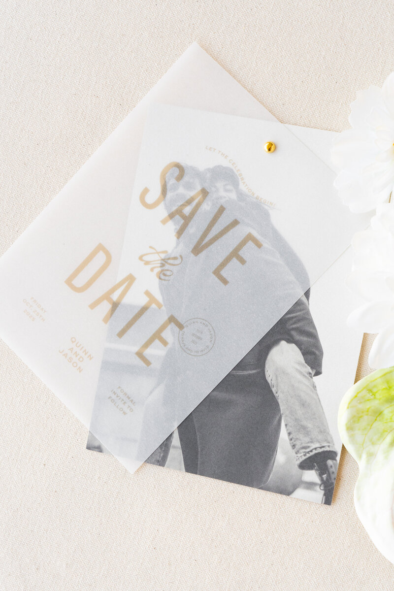 White curved menu card on a plate with a brown velvet napkin and flowers