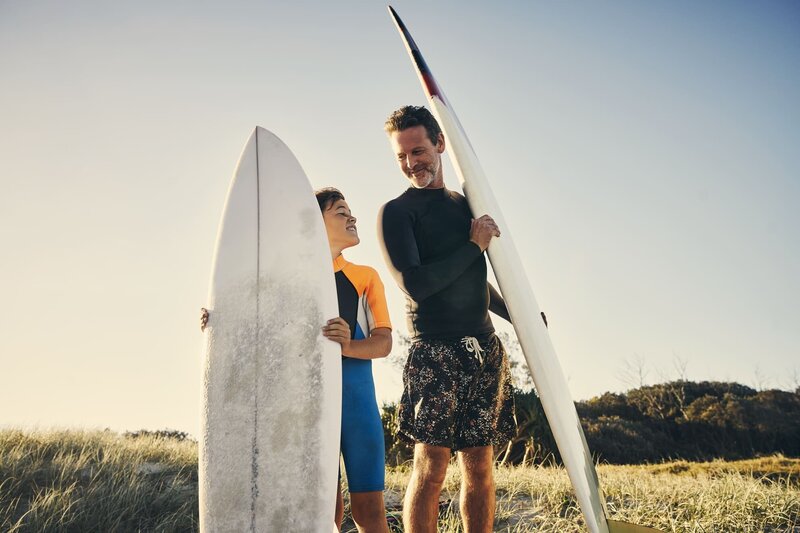 man and son preparing to go for a surf