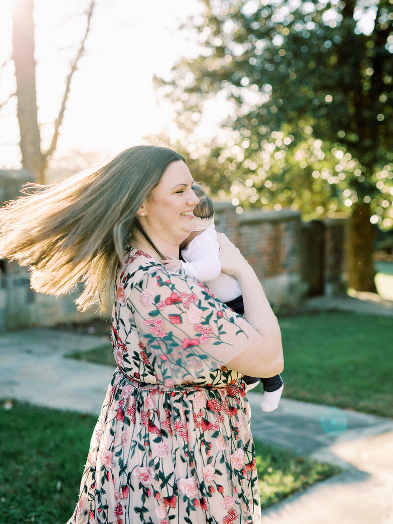 A mother smiling while holding her baby at a Richmond family photography session by Katie Stansfield Photography.