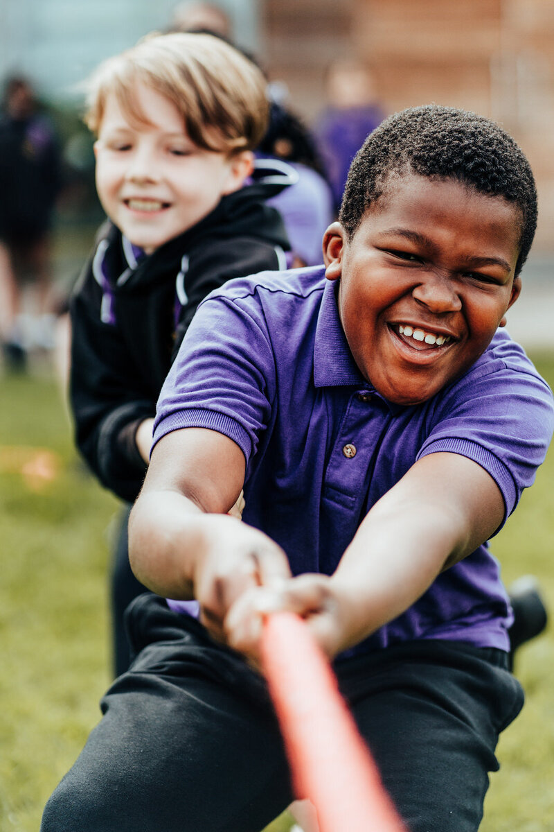 Boy from Cambridge Primary School playing tug on war