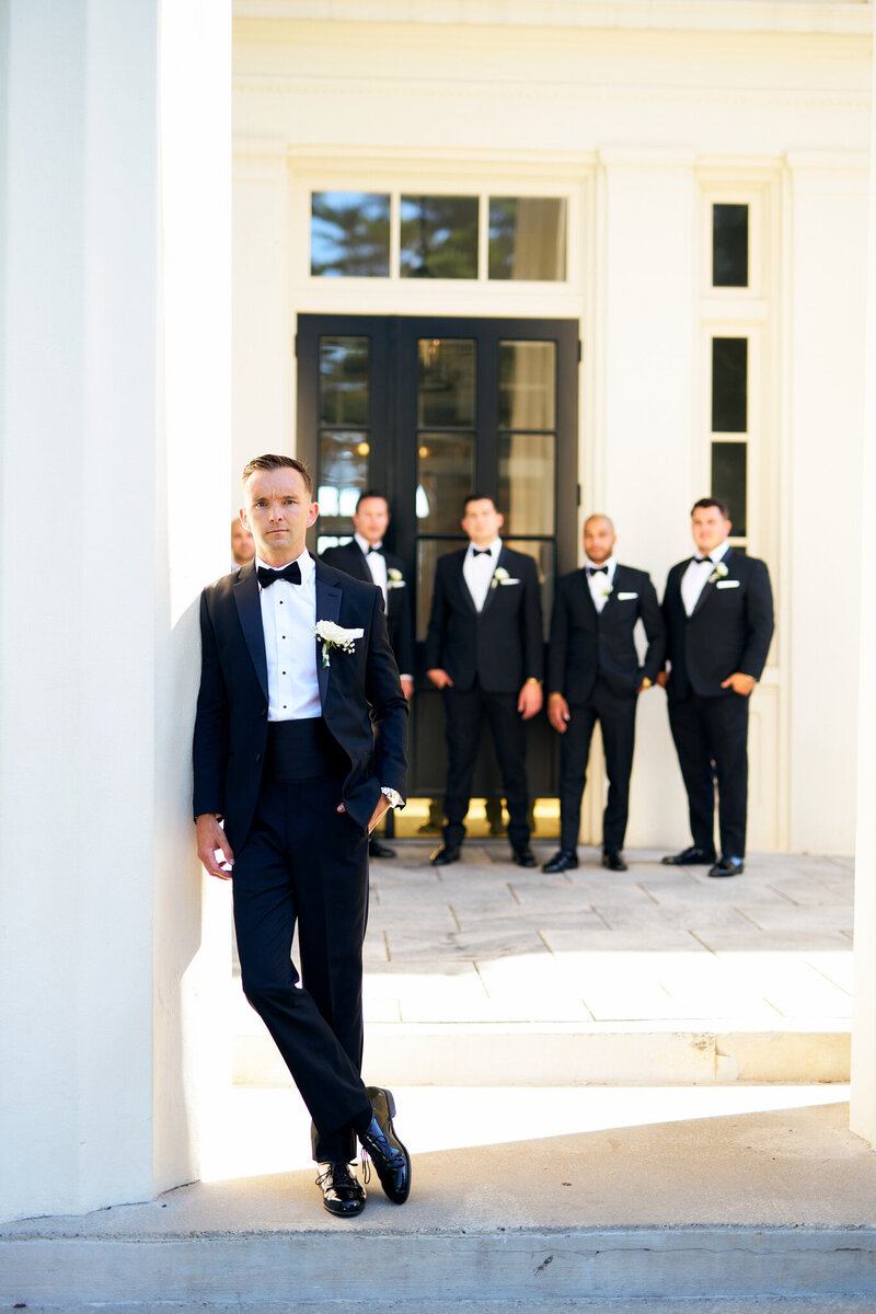 a man and his groomsmen taking photos infront of wadsworth mansion in middletown Connecticut