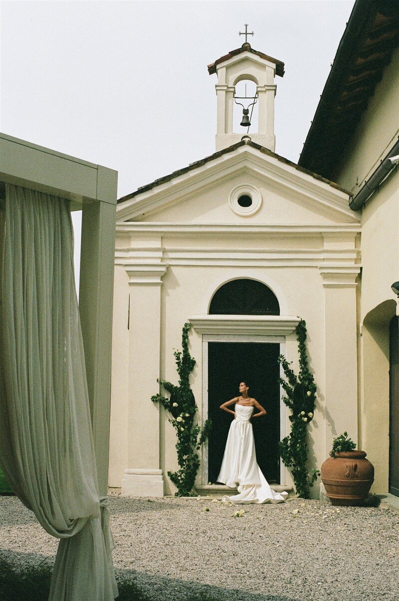 bride posed in front of wedding venue in Italy