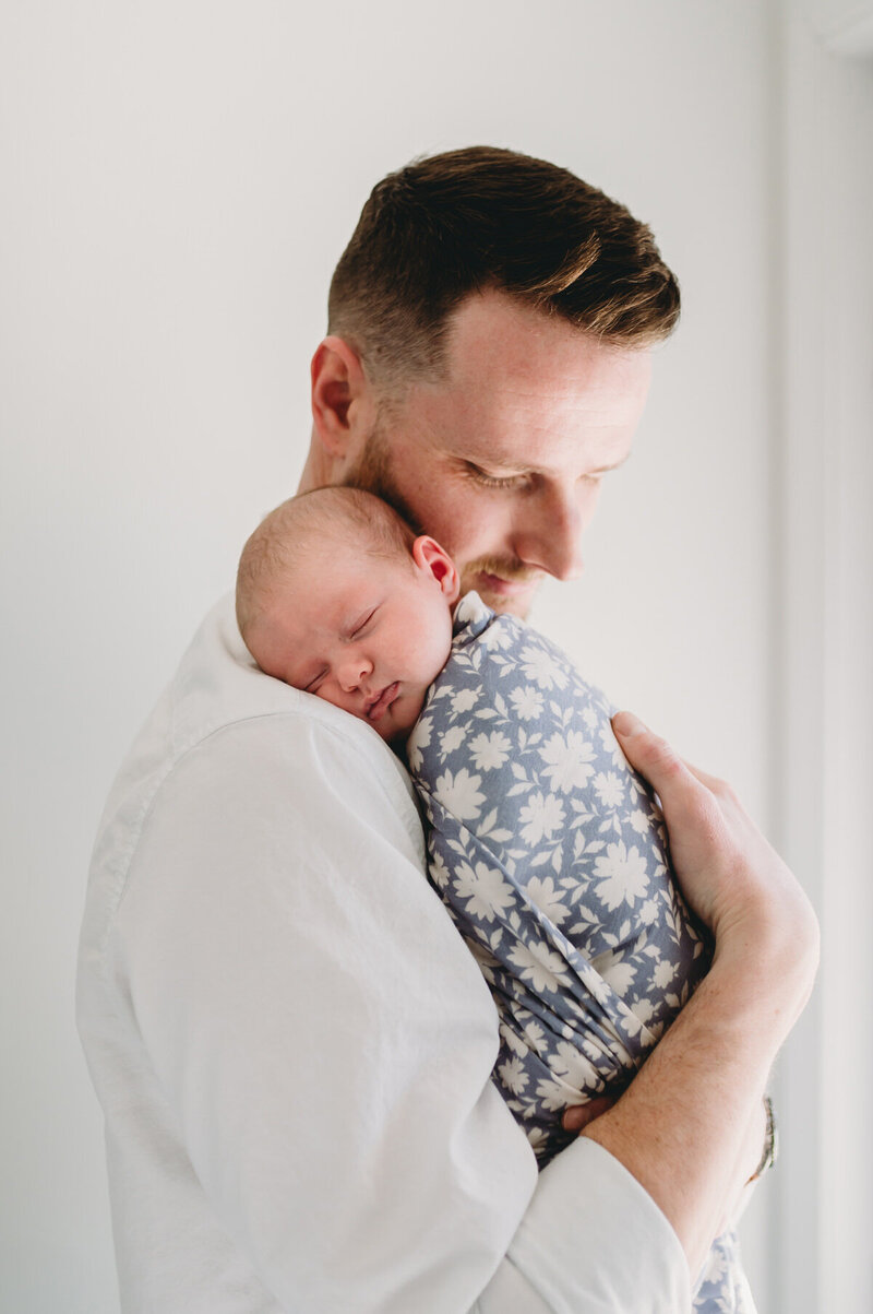 dad holding baby on his shoulder