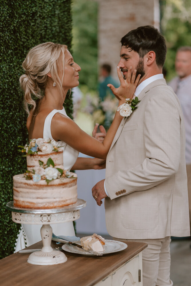 Bride putting cake on grooms face