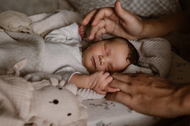 Baby slaapt op bed bij papa