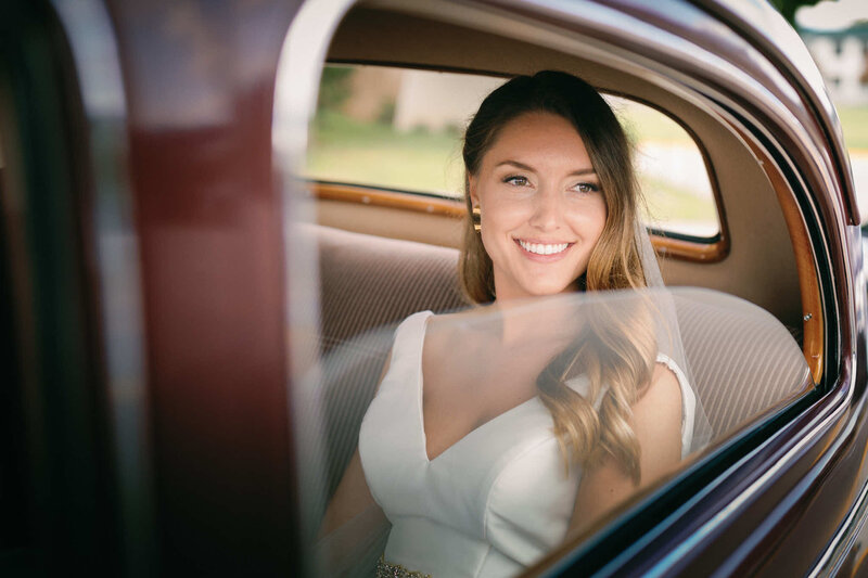Bride posing for a bridal portrait in a car.