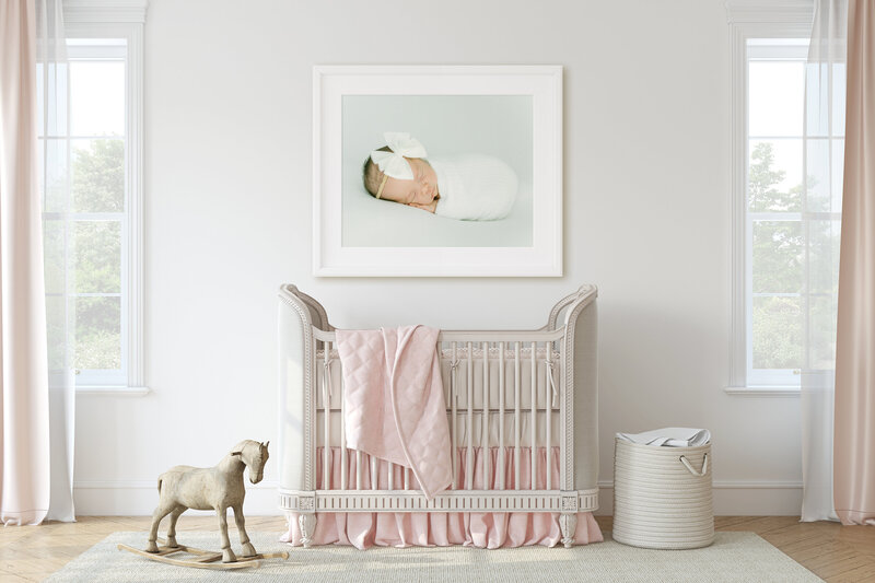 Framed photo of a newborn hanging above a crib in a luxury Dallas nursery.