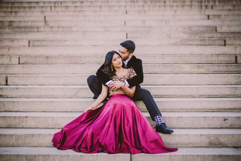 A couple sharing a moment while sitting on the stairs during their engagement session at central park in nyc at bethesda terrace