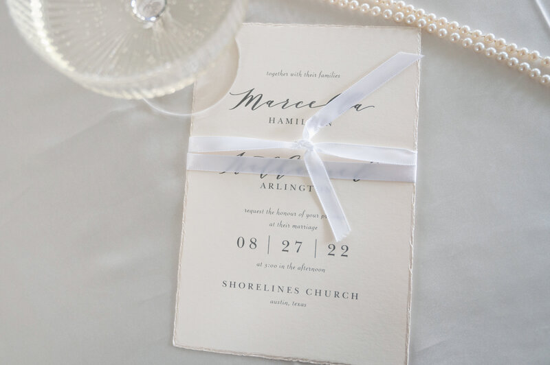 deckled edge wedding inviation with ribbon, pears and champagne coupe