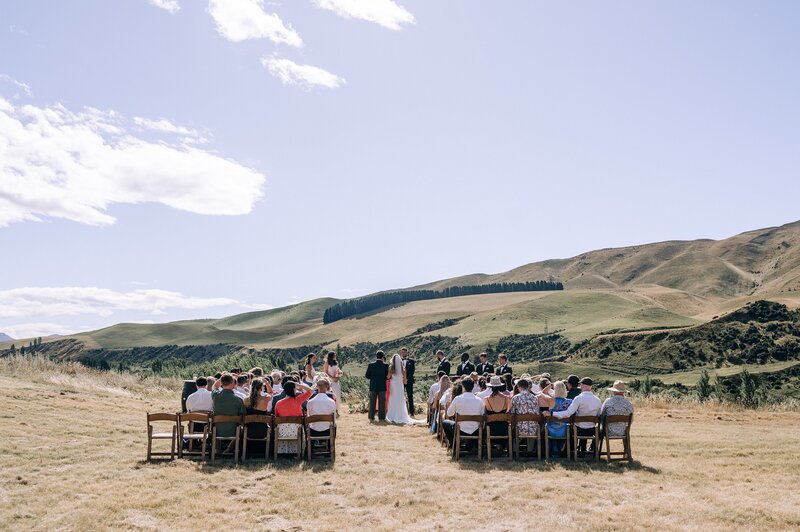 a wedding ceremony with brown wooden chairs at the boneline vineyard in waipara near christchurch