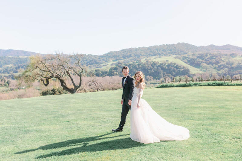 bride and groom walking hand in hand at Sunstone Winery in California