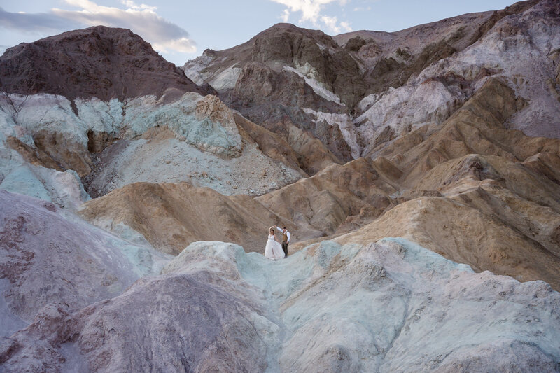A couple slow dances among colorful hills in Death Valley