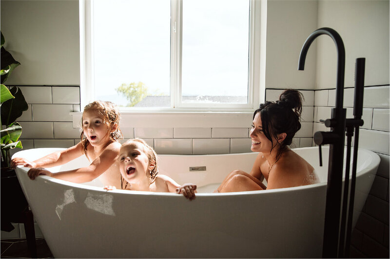 woman in the tub with her children, all laughing