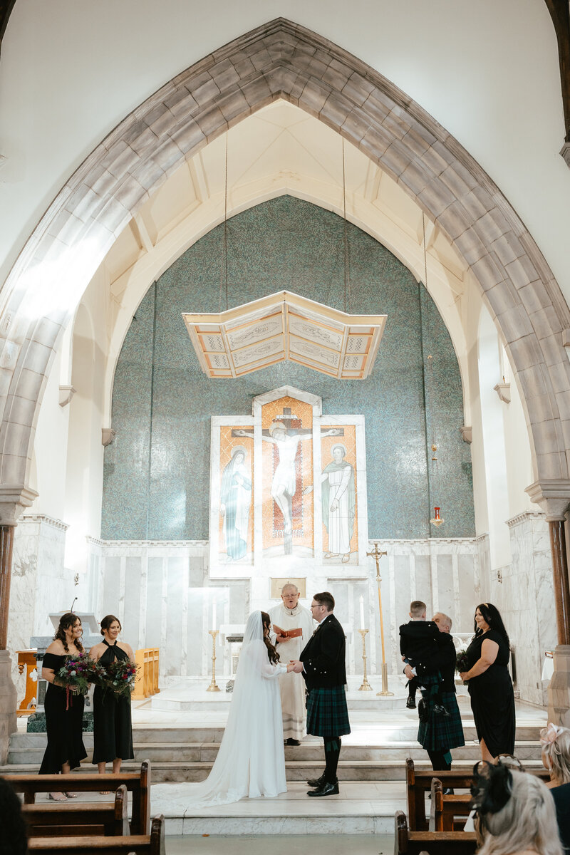 A bridal couple exchange vows at the alter