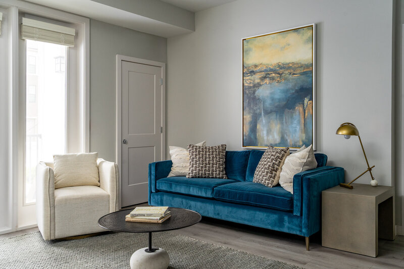 model home design with blue sofa and art by Gracious Home Interiors