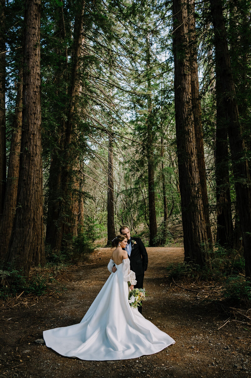 Bride and groom standing in forest on their wedding day