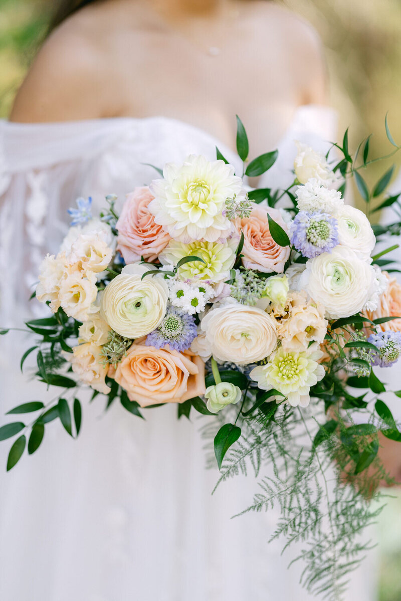 A radiant bride holds a beautiful bouquet on her wedding day at Emerald Lake Lodge. Captured on a warm summer’s day in Banff National Park, this moment exudes natural elegance and timeless romance.