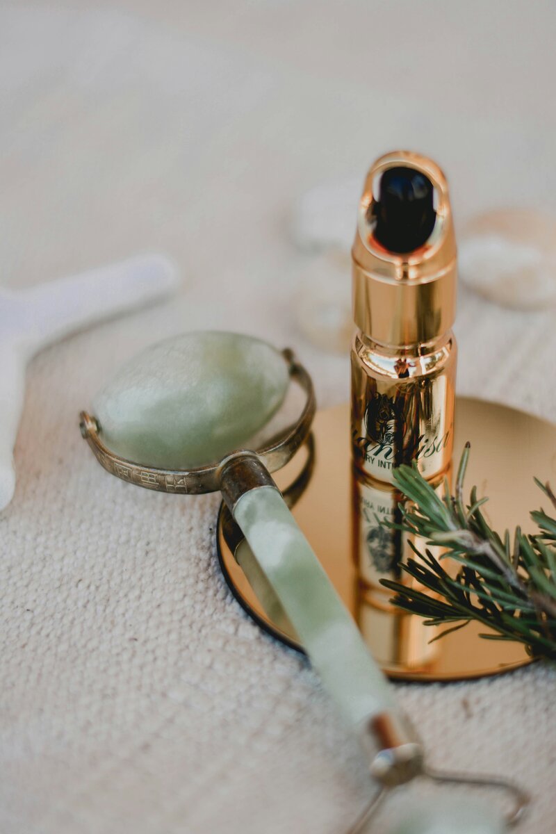 Skincare products laid on a white sheet with lavendar and a candle