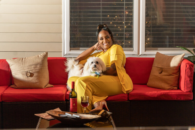 50th milestone birthday photoshoot woman wearing mustard colored romper sitting by outdoor firepit