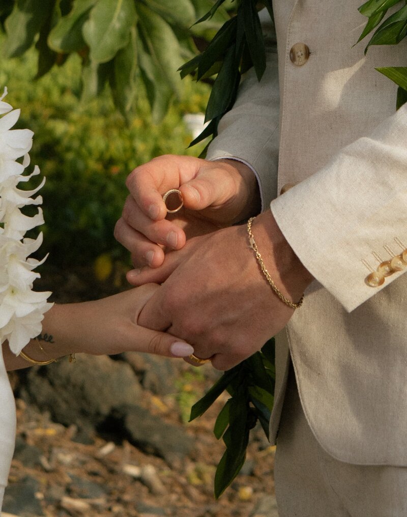 groom putting a ring on a brides hand