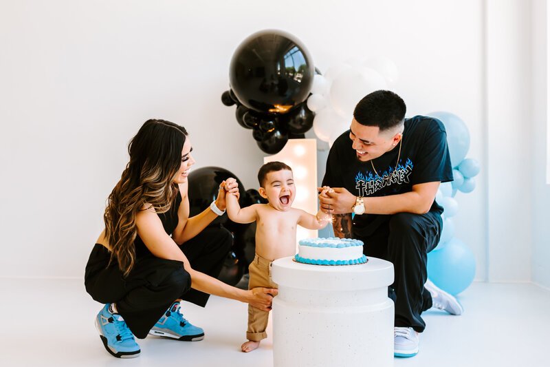 baby sitting on floor with balloons in background