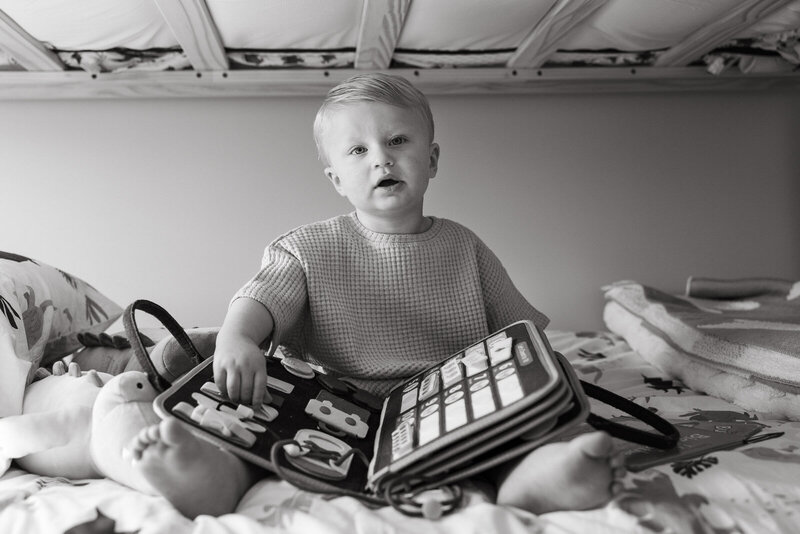 Black and white portrait of a toddler holding a toy and staring at the camera taken by Jennifer Mosier Photography. 