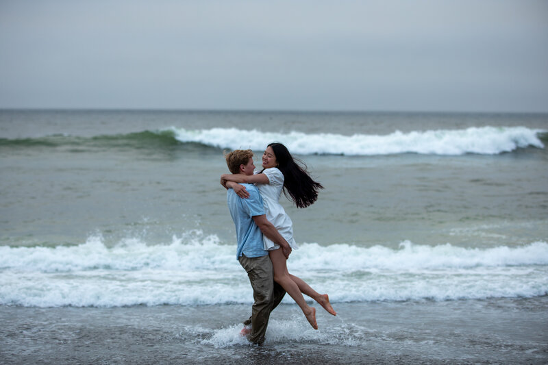 Couple dances in the waves on the California coast