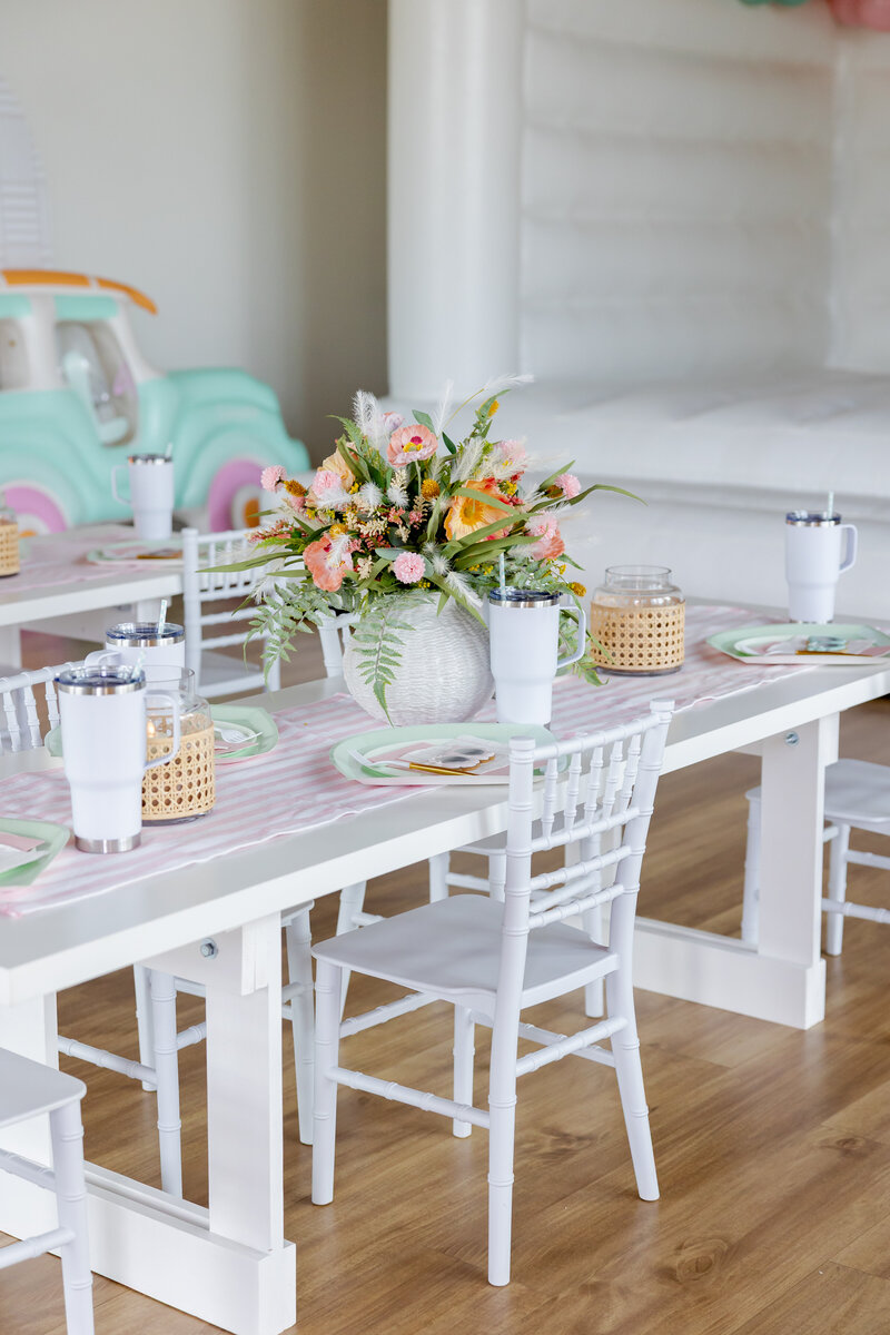 Kids decorated table for a pool cabana party. White table and chairs.