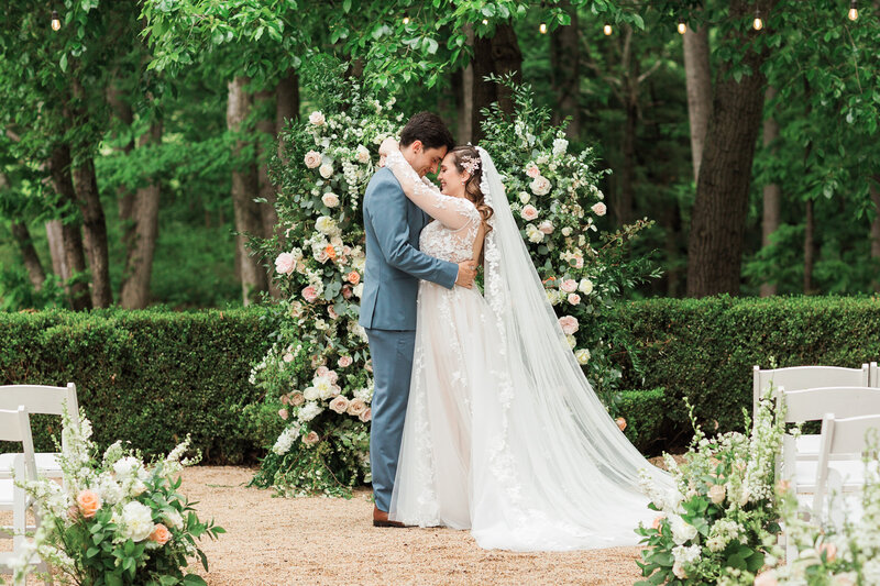 Bride and groom at a Charlottesville Winery wedding with a blush floral arch