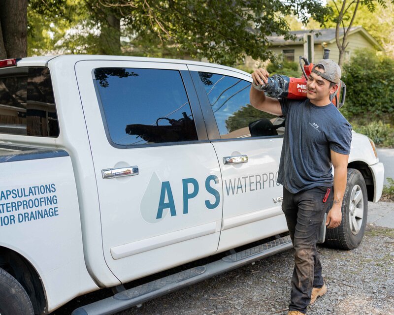 Man carrying equipment to perform basement waterproofing services in Atlanta