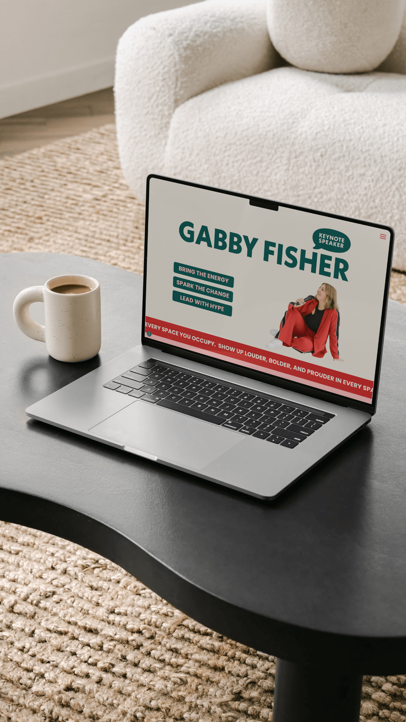 A black laptop sits on a wooden table, displaying the words “GRAND SALON” in elegant white letters on its screen—a stylish example of hair salon website design. The background features soft, light-colored curtains.A wooden chair with a woven seat and backrest sits on a black-and-white checkered floor, near a white curtained window—an elegant touch perfect for a hair salon website design. Above the chair is a black circle with a white letter G.
