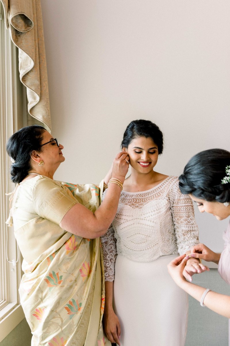 bride getting ready with mom and sister