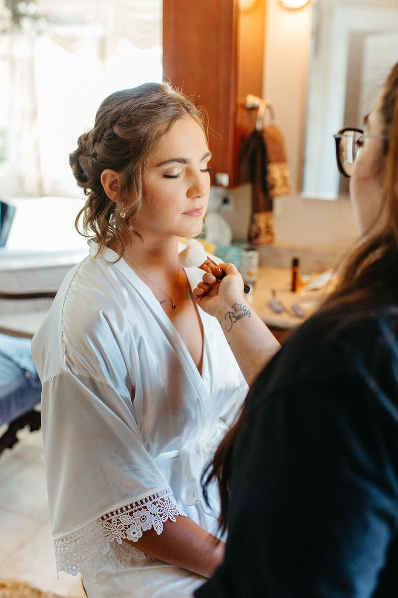 bride doing makeup St. Louis Wedding Photographers
