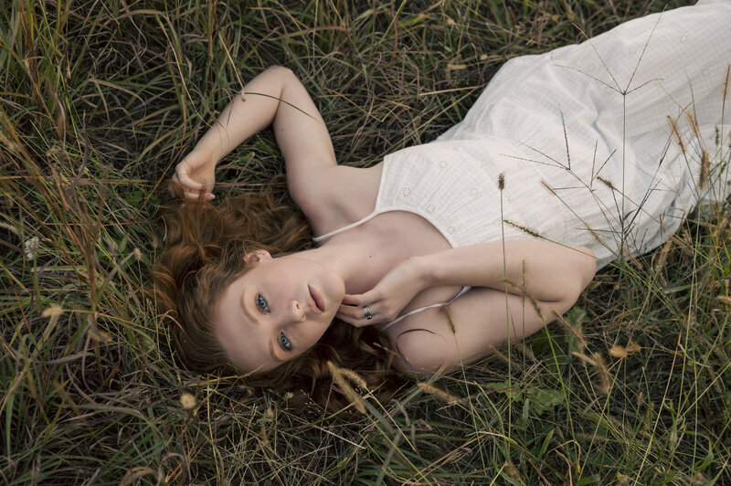 Woman laying in the Tall grass prairie