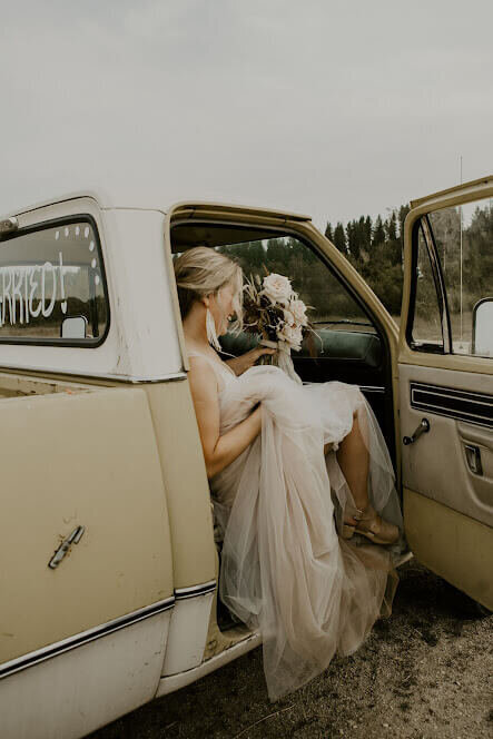 A bride gets out of a pick up truck representing the fun and non-traditional nature of the bridal show vendors and guests at The Crush Collective.