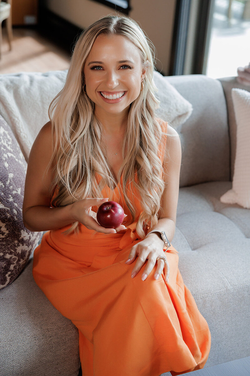Bonnie Roney of Diet Culture Rebel Smiling and Holding an apple