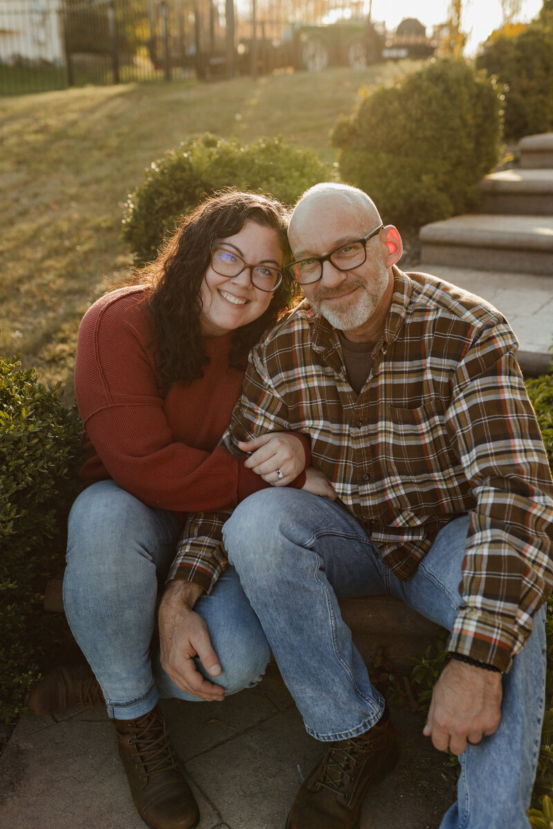 Stacy Lexus and her husband standing amidst fall foliage