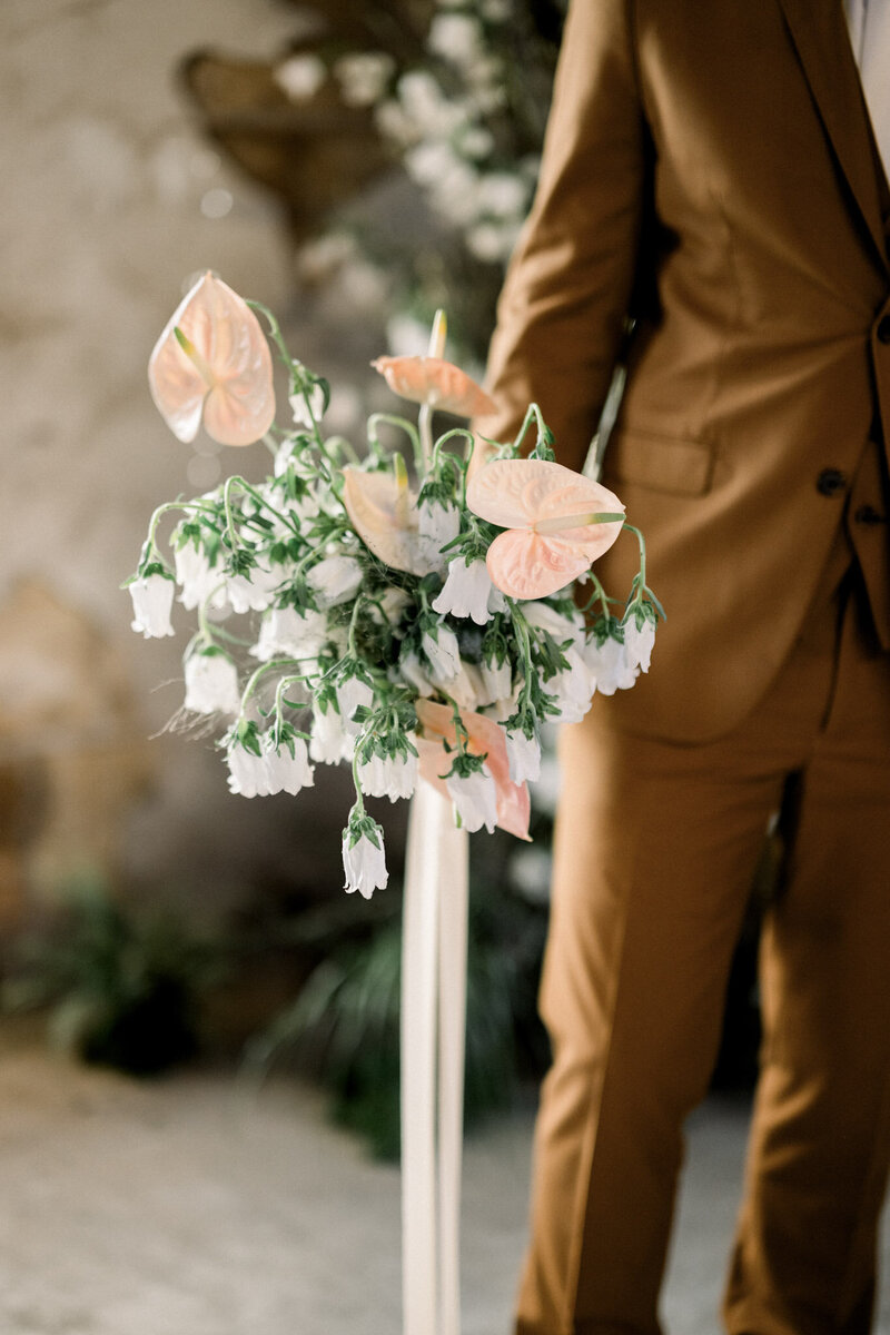 Close-up of an elegant wedding bouquet with white and green flowers and foliage.