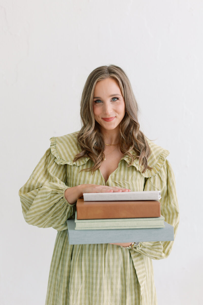 Headshot of Tulsa OK photographer in studio, holding hair back from face wearing white dress and turquoise bracelets