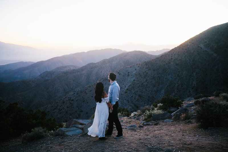 man and woman look out at view during dusk