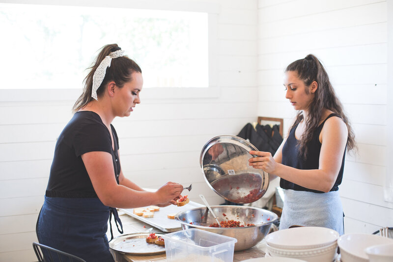 two women work on making bruschetta