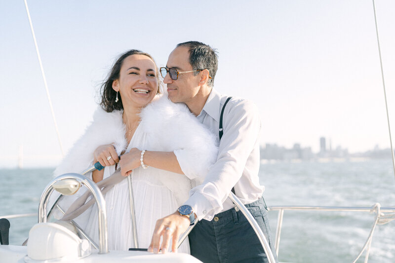 couple on a sailboat smiling at each other