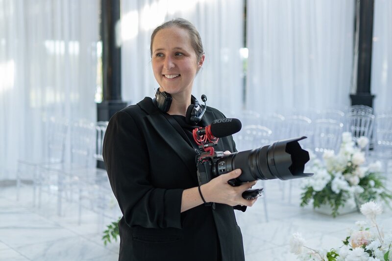 A person holding up a camera on a small pole smiling 