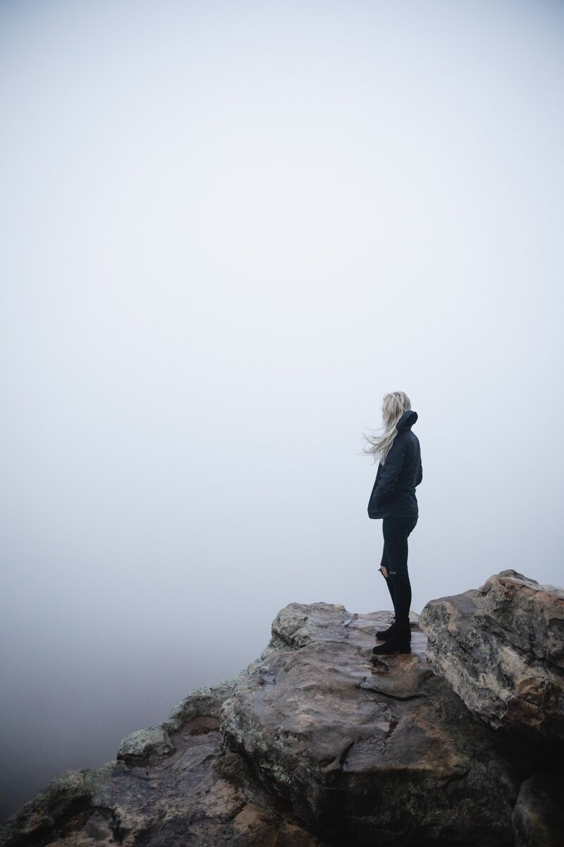 Woman standing on cliff in the fog  in Asheville North Carolina