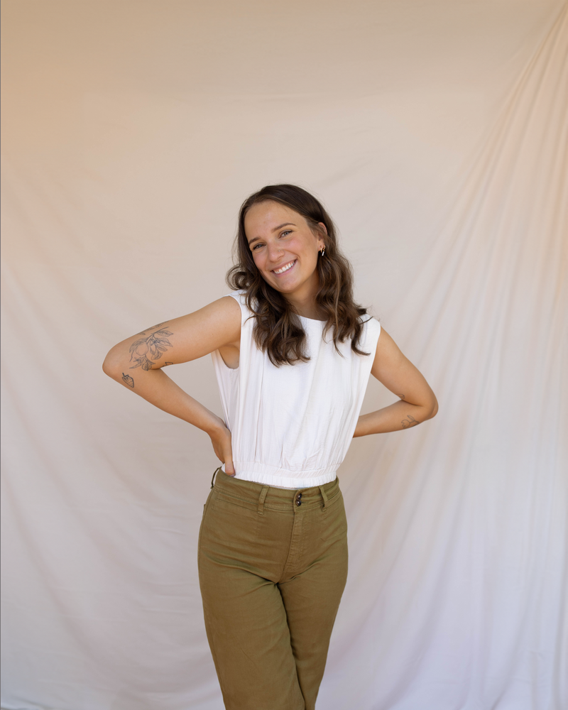 A woman smiling with a handful of colorful pantone color palette swatches.