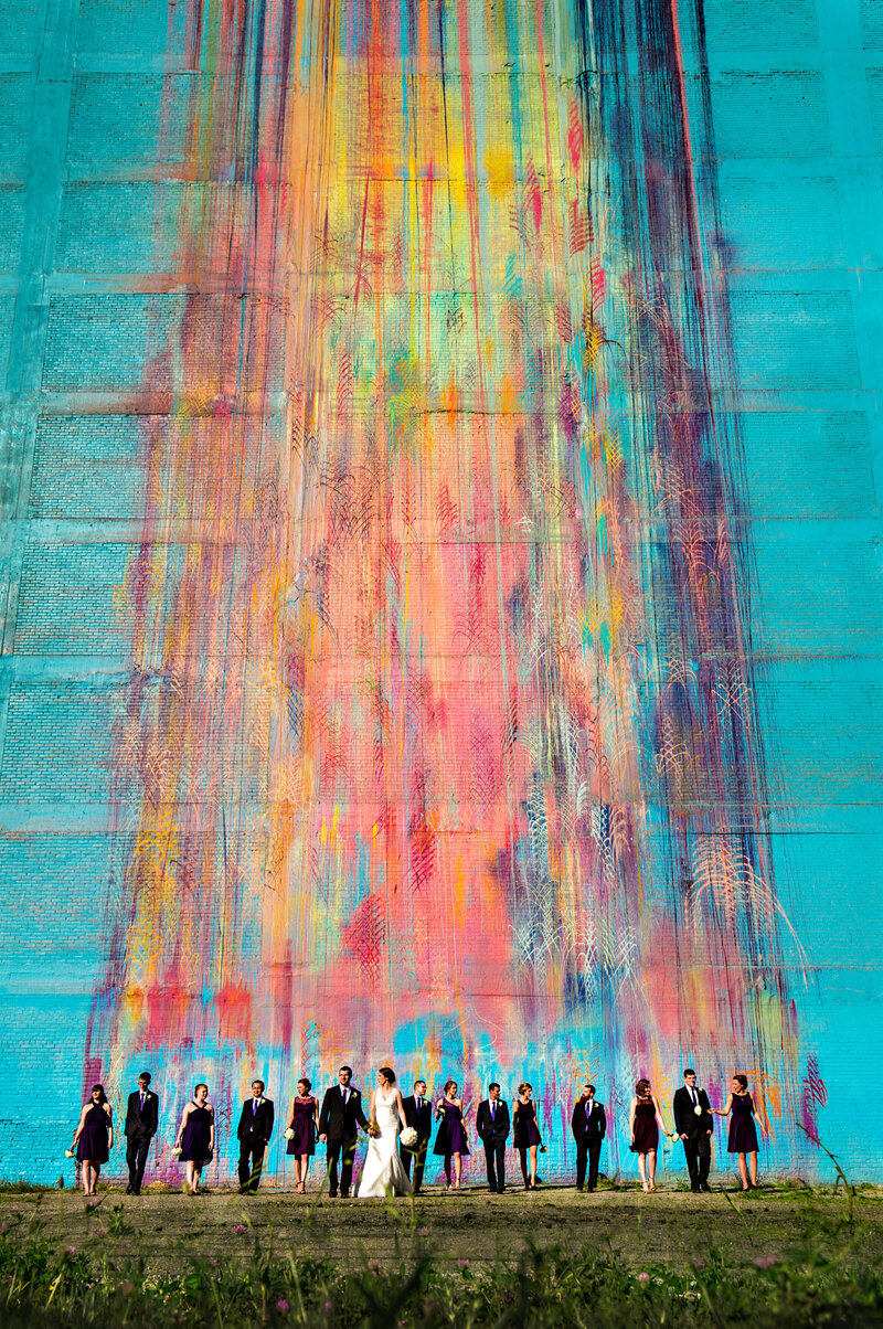 A colorful mural is the backdrop during a wedding party portrait in Detroit.