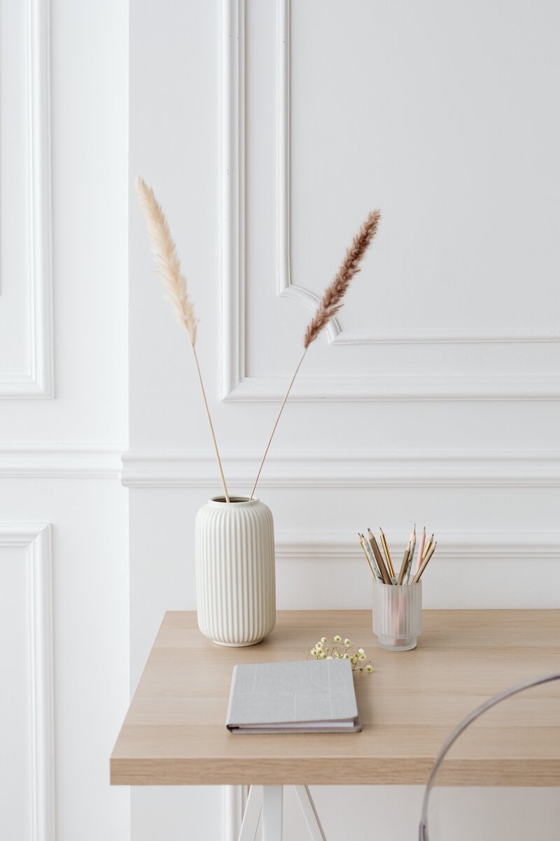 Vase avec fleurs séchées sur un bureau