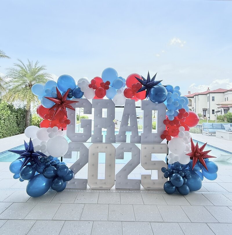 Marquee letters for a graduation with navey white and red balloon garland